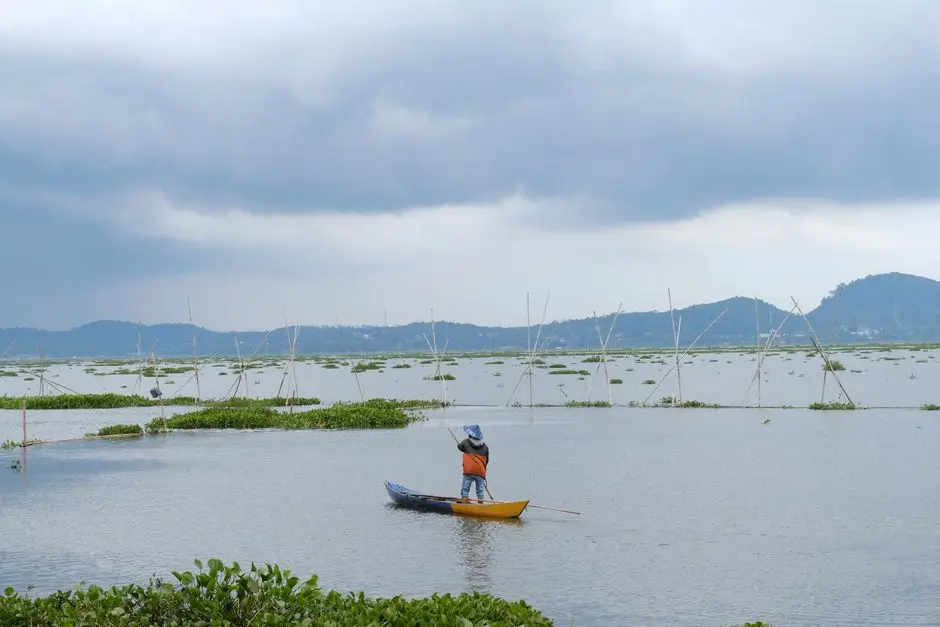Suasana Danau Limboto di Gorontalo dengan perahu nelayan dan latar bukit hijau